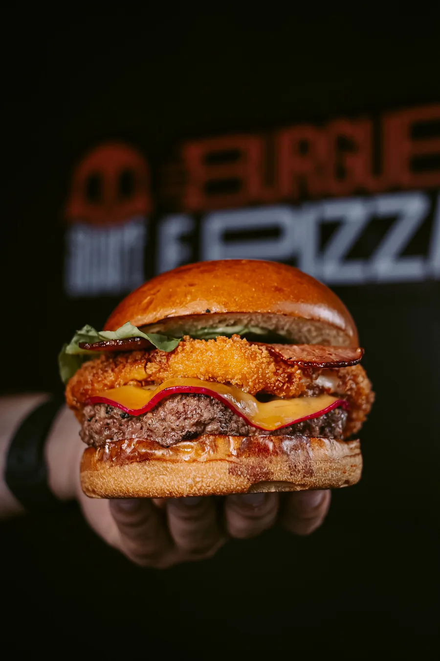 Hambúrguer com onion ring empanado, bacon, cheddar e alface